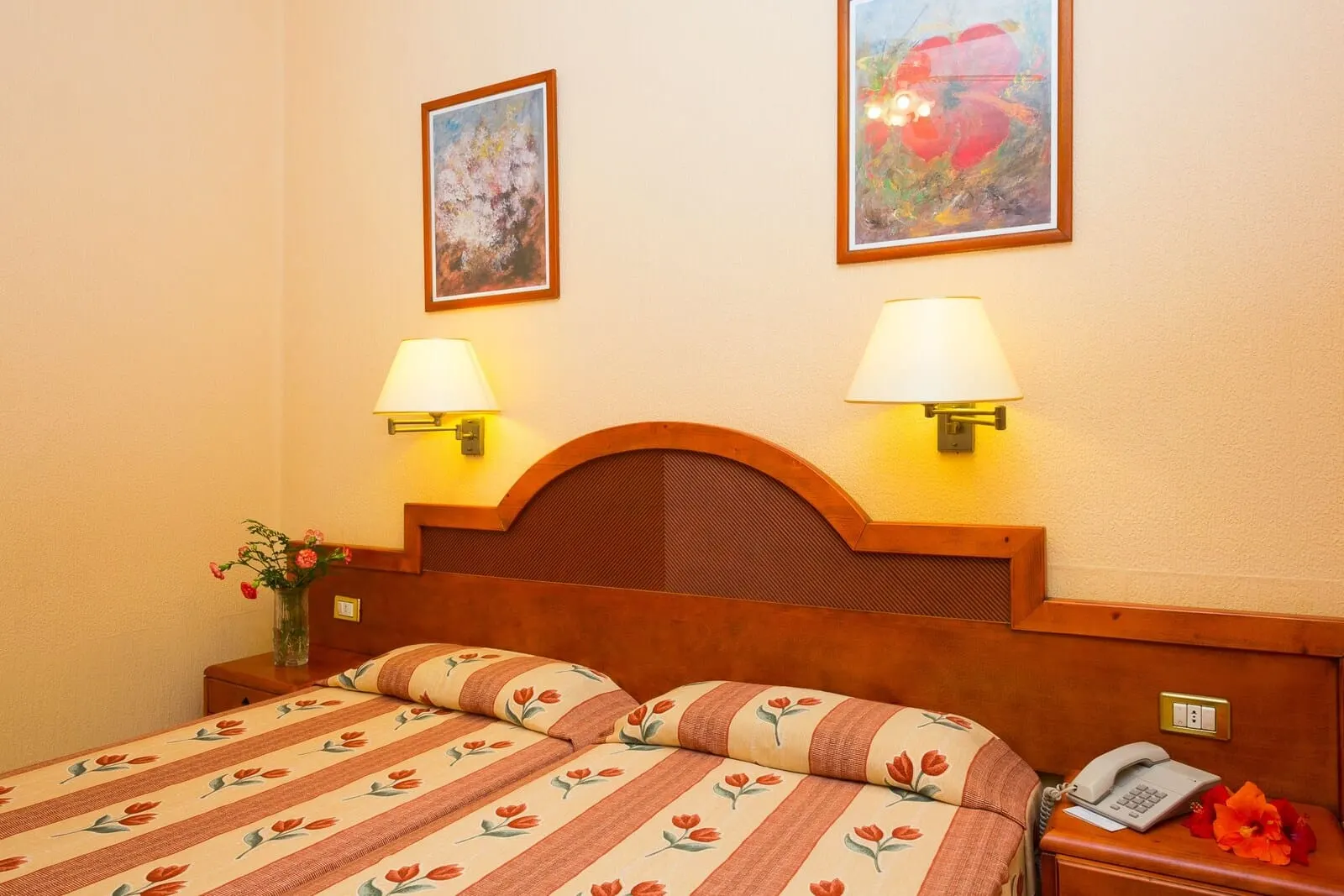 Hotel Monopol: A hotel room with a wooden headboard, two bedside lamps, a telephone
