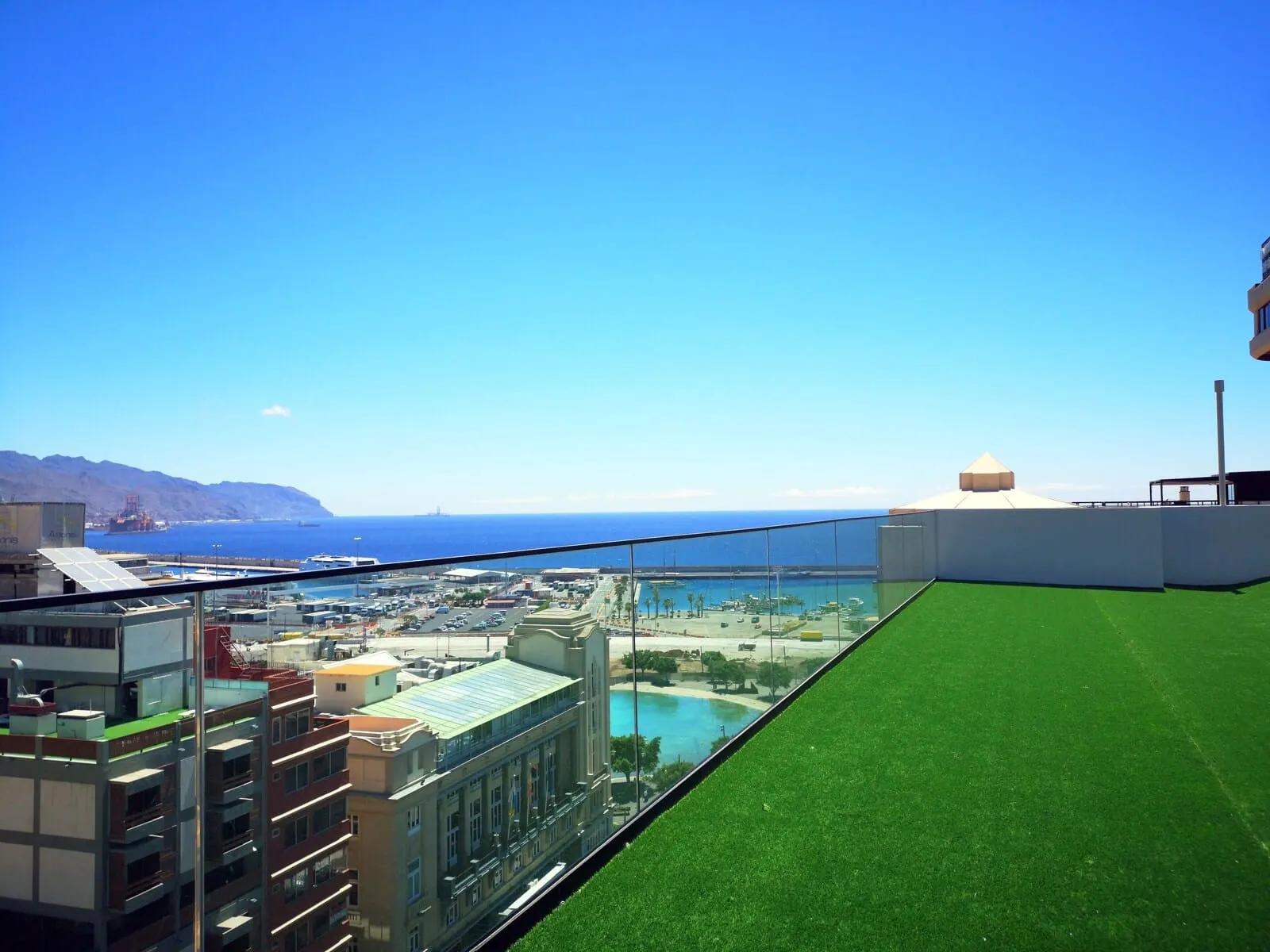 Hotel Adonis Capital: A high-rise building with a rooftop pool and a view of the sea