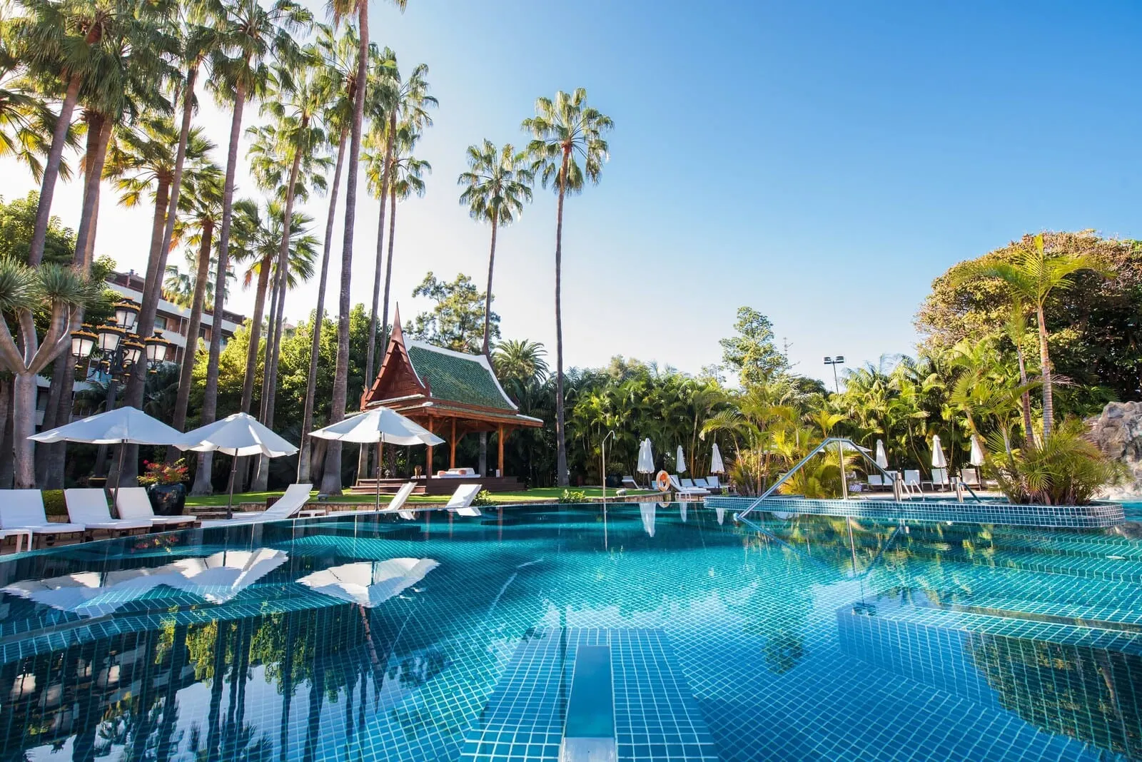 Hotel Botánico & The Oriental Spa Garden: A swimming pool with tiled flooring, surrounded by lounge chairs and umbrellas