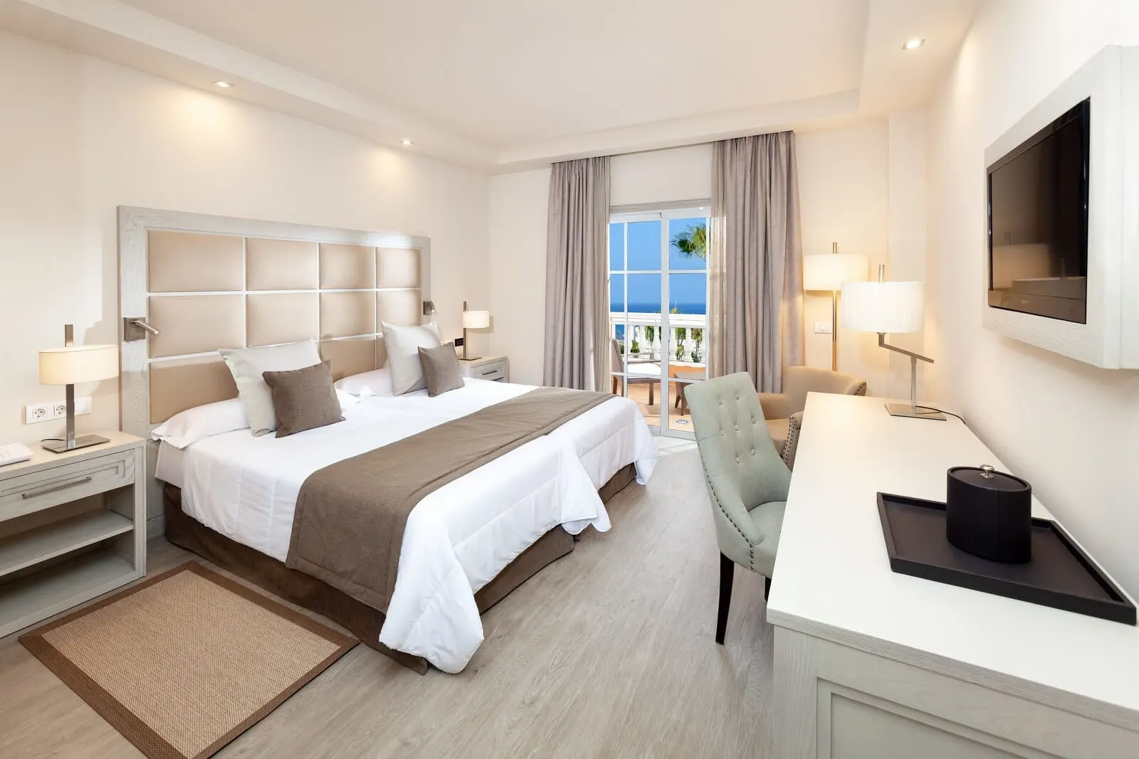 Hotel Riu Garoé: A hotel room with a large bed, a desk, a chair, and a TV