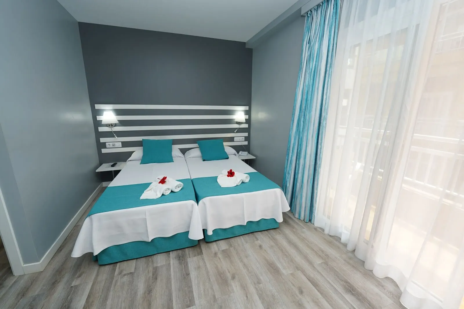 RF Apartamentos Bambi: A hotel room with two beds, a modern headboard, a nightstand