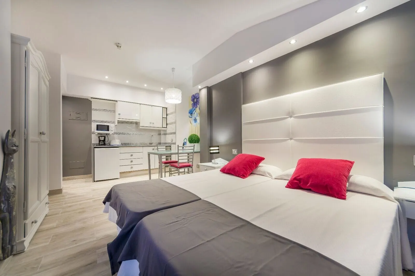 Hotel Sun Holidays: A modern hotel room with a large bed, a desk, and a kitchenette