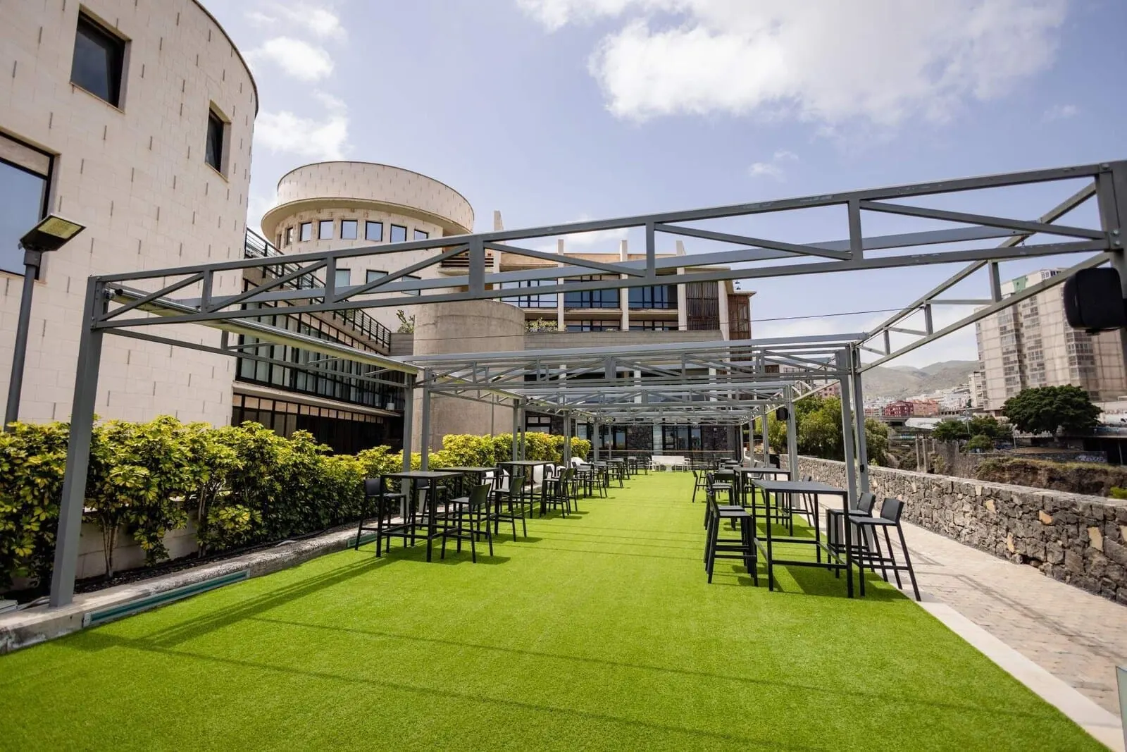 Hotel Escuela Santa Cruz: An outdoor seating area with a metal pergola structure, green artificial grass
