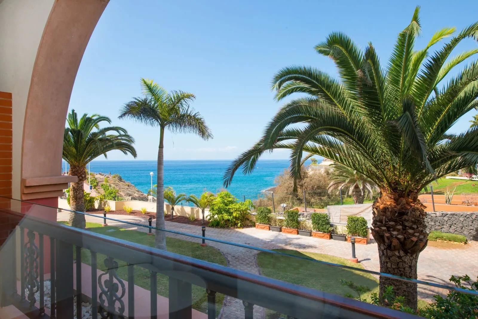 Iberostar Selection Anthelia: A balcony with a view of the sea, palm trees, and a stone wall
