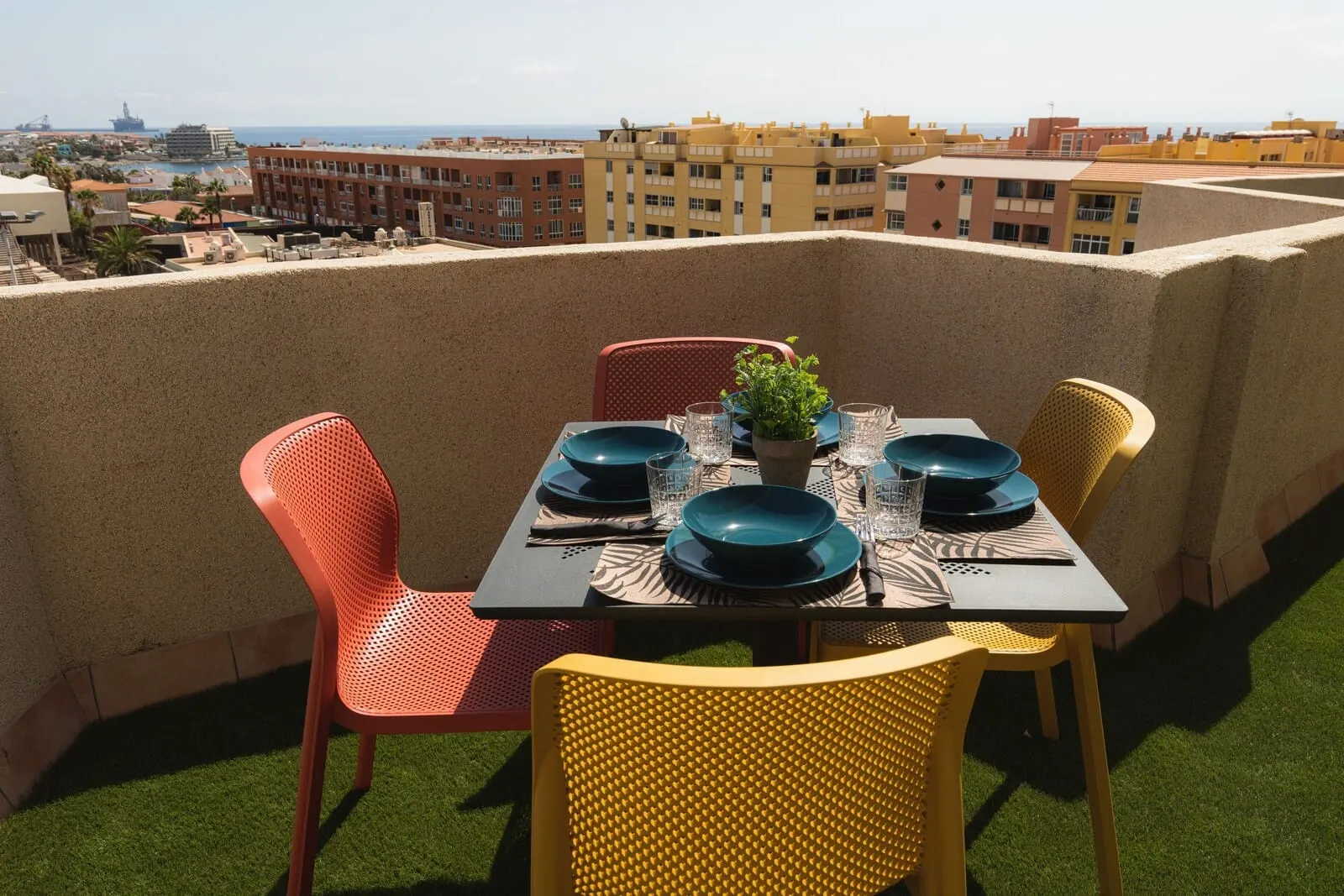 Hotel Ventus: A table set outdoors with chairs, a potted plant, and a view of the cityscape