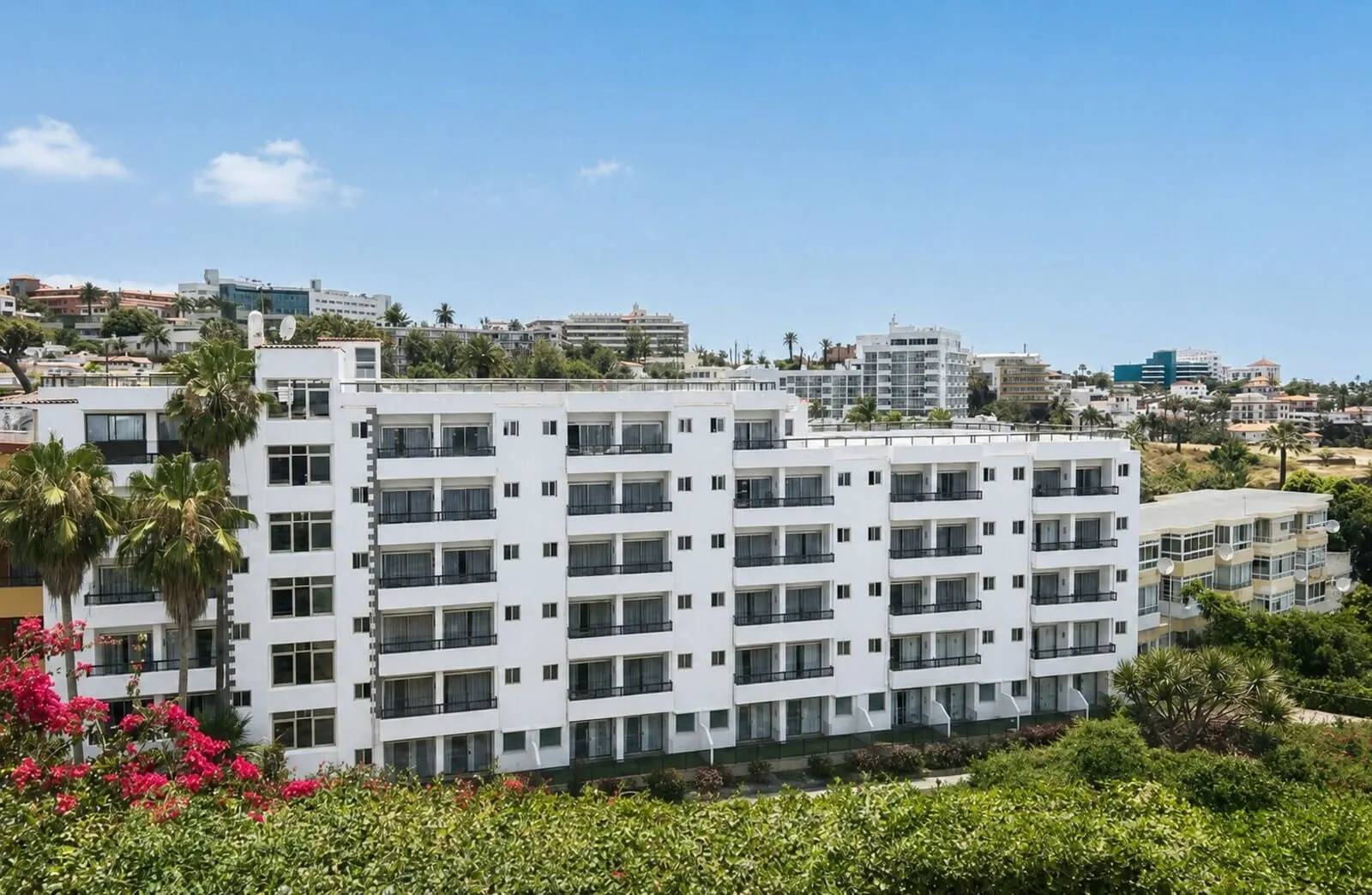 Muthu La Perla Tenerife: A multi-story hotel with balconies, surrounded by greenery and other buildings