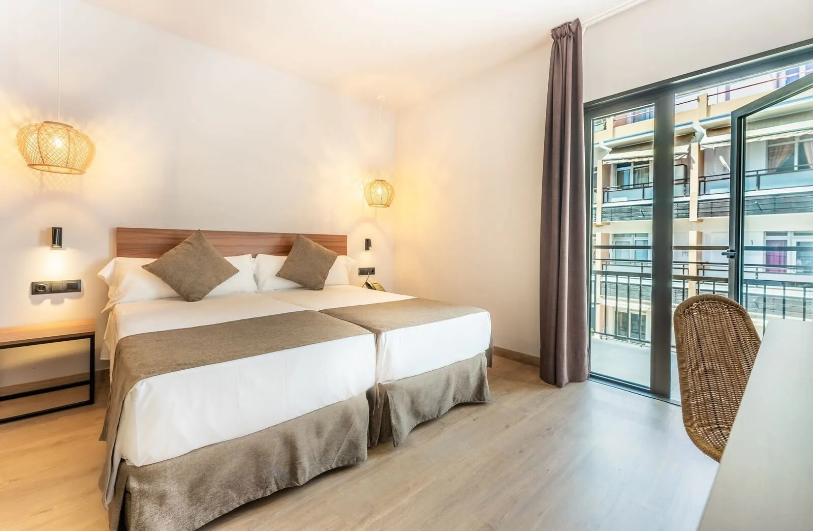 DWO Nopal: A hotel room with a double bed, bedside lamps, a view of the building's exterior