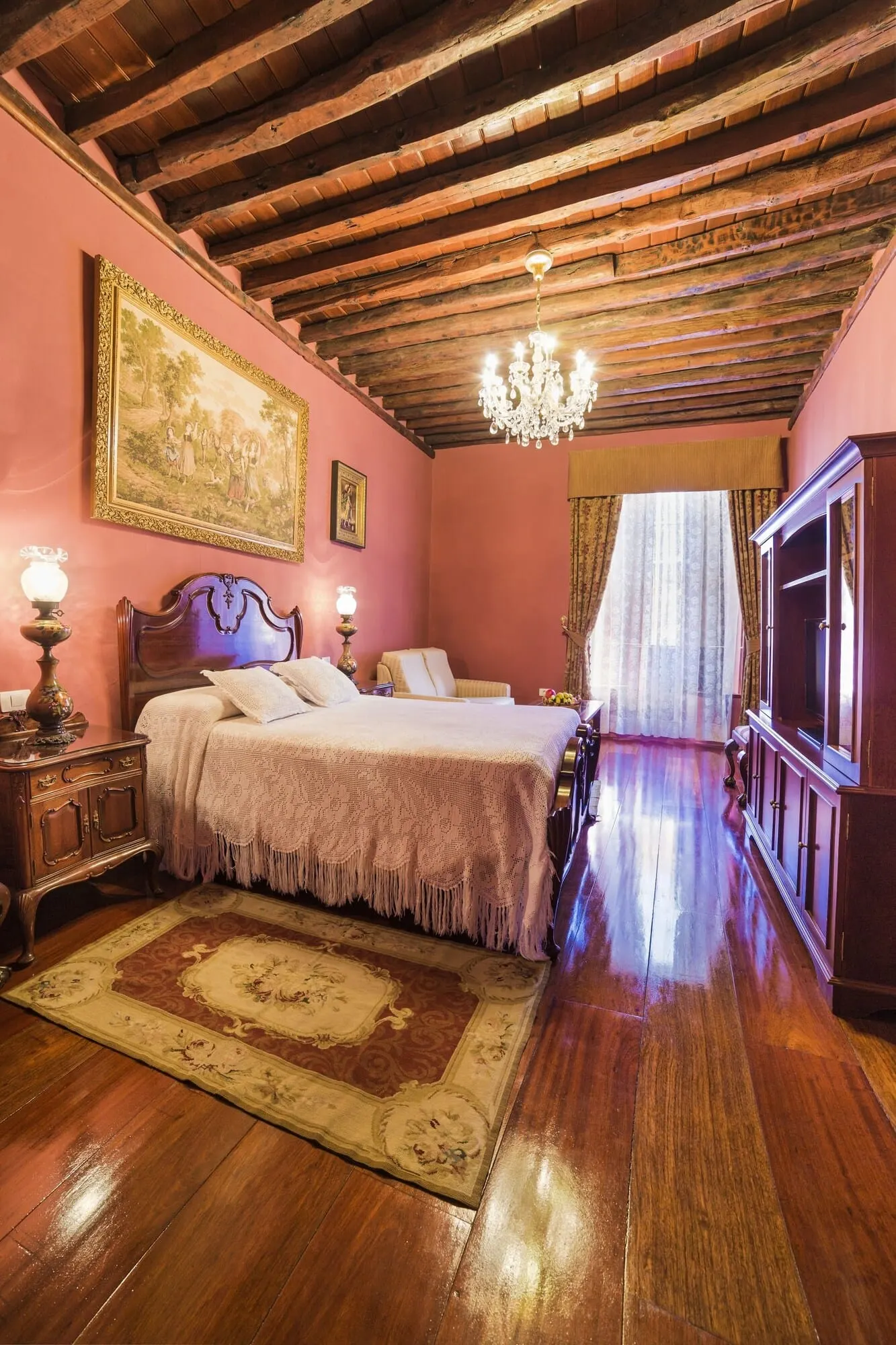 Hotel Emblemático San Marcos: A bedroom with a wooden ceiling, a large bed with a headboard, a chandelier