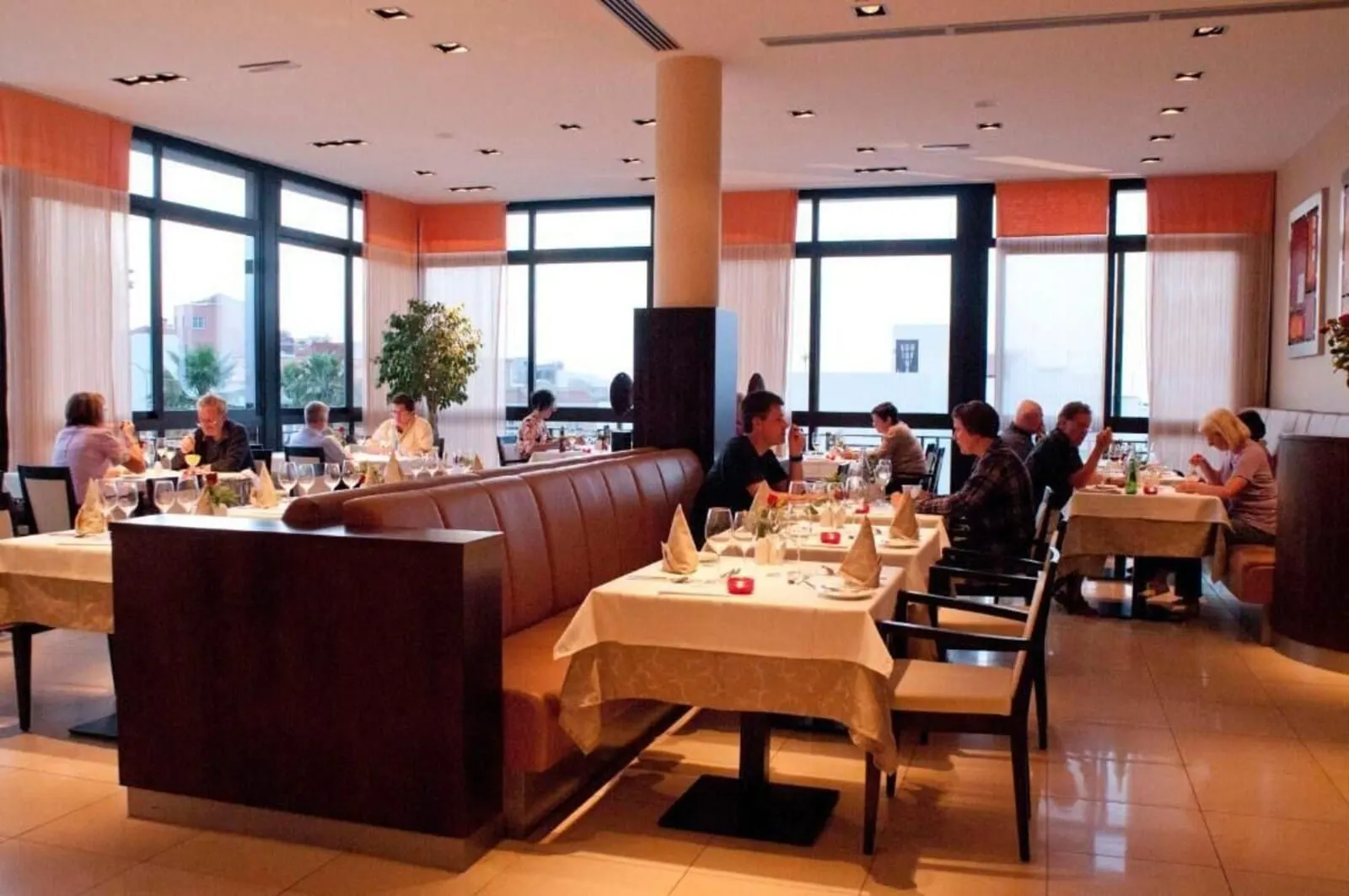 Hotel Luz del Mar: A restaurant with multiple tables and booths, large windows