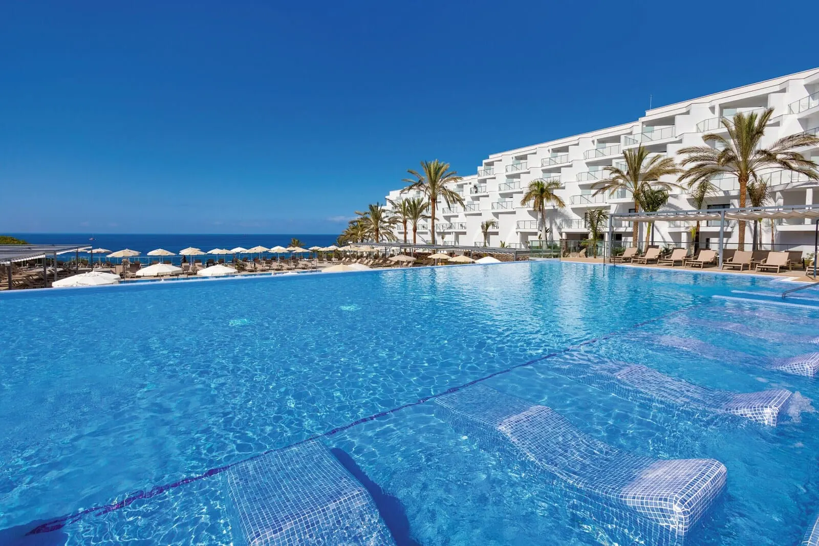 Hotel Riu Buenavista: A clear blue pool with lounge chairs and umbrellas