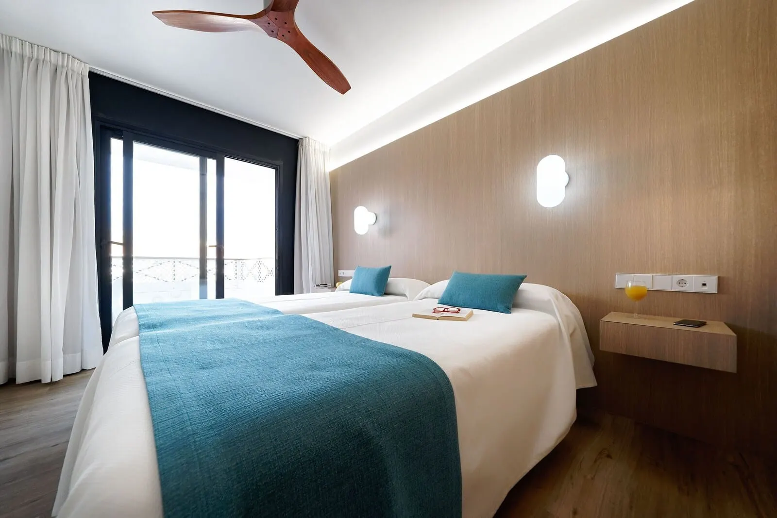 Hotel Parque La Paz: A hotel room with a large bed, two bedside tables, a ceiling fan
