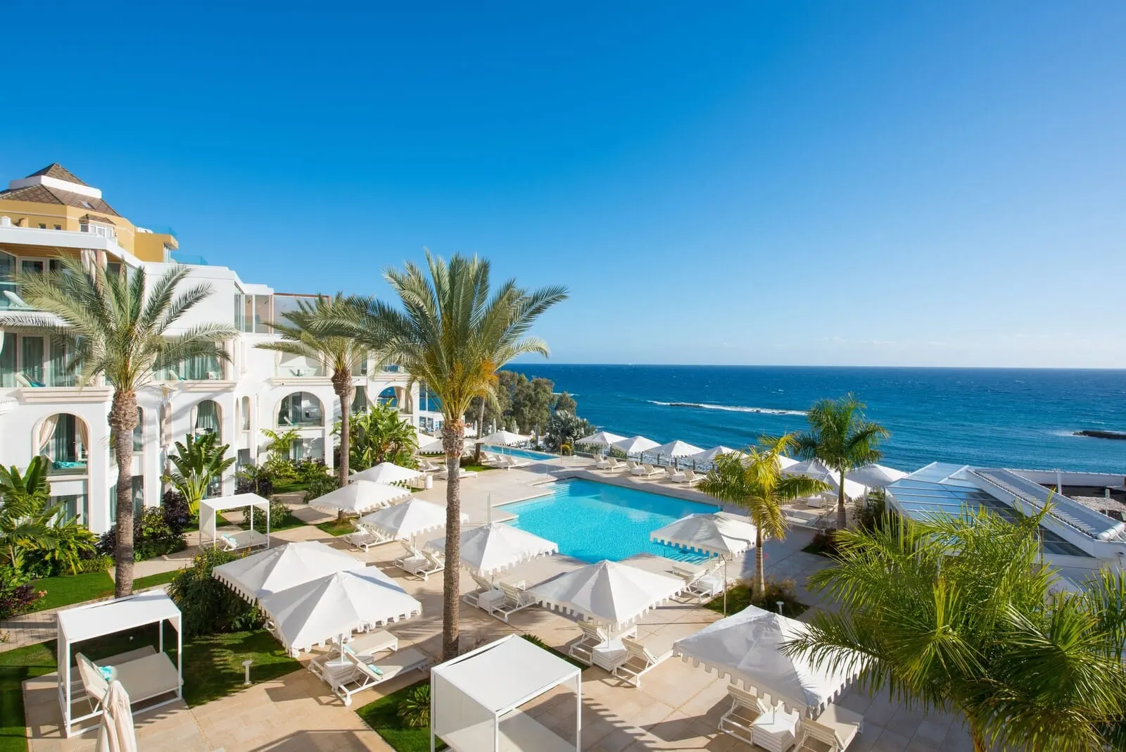 JOIA Salomé by Iberostar: A resort with a swimming pool, palm trees, and ocean views