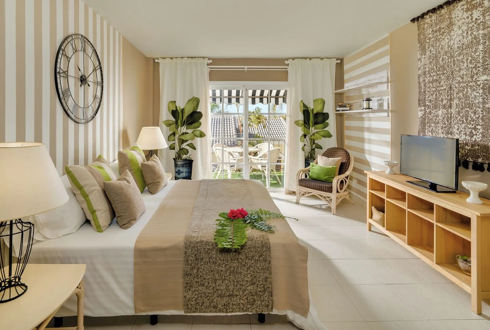 Gran Oasis Resort: A hotel room with a bed, a TV, a wooden TV stand, a large clock