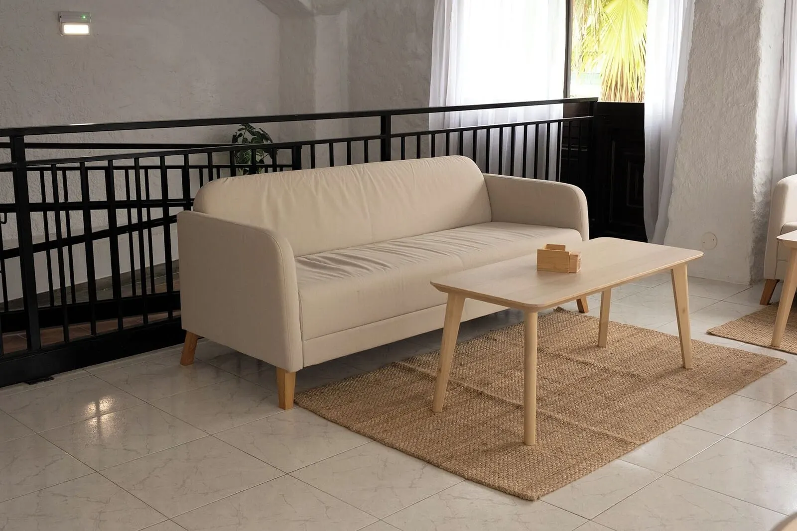 Muthu La Perla Tenerife: A living room with a sofa, a small wooden table, a black railing