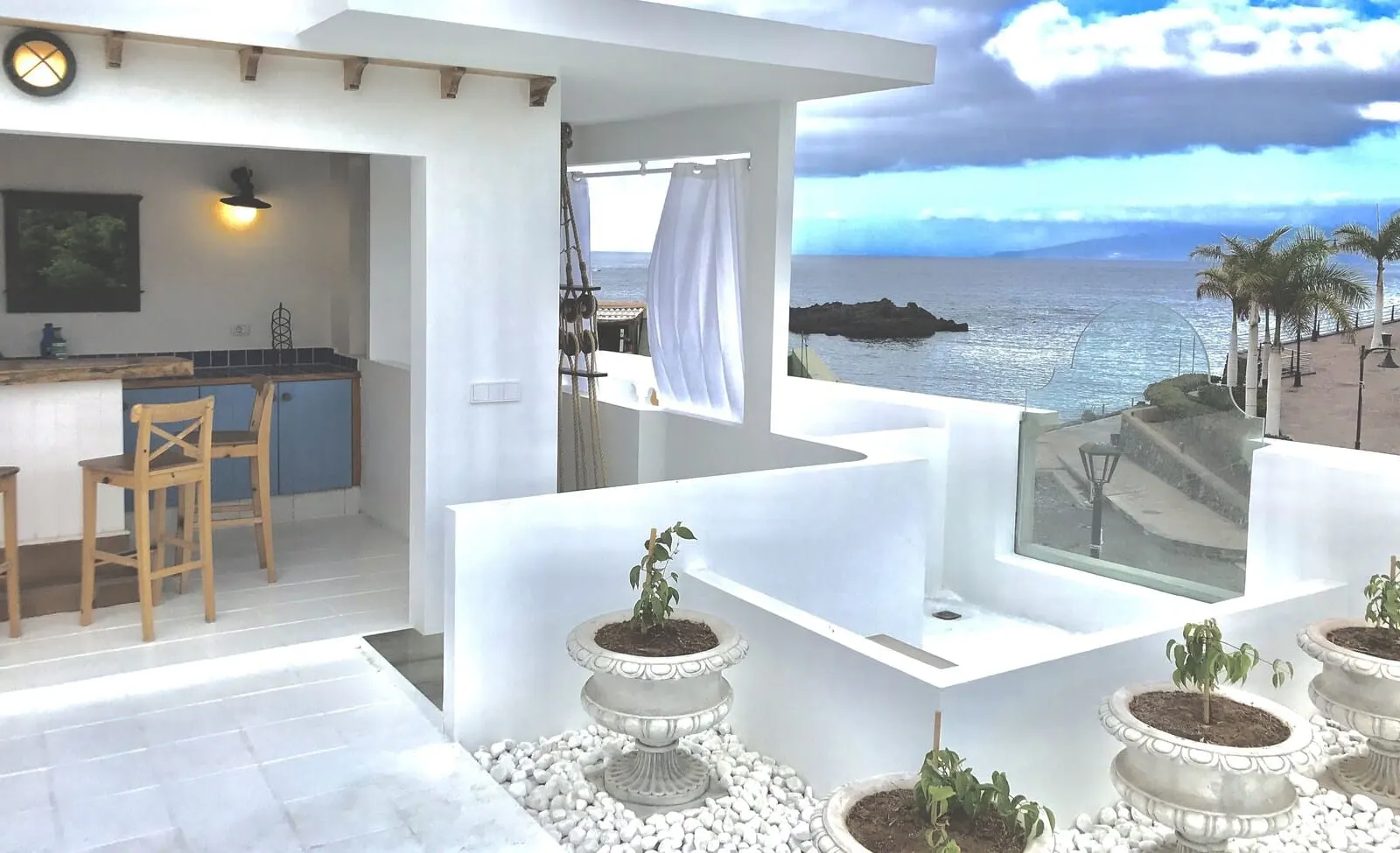 Rok Plaza: A modern interior with a kitchen area, bar seating, and a view of the sea
