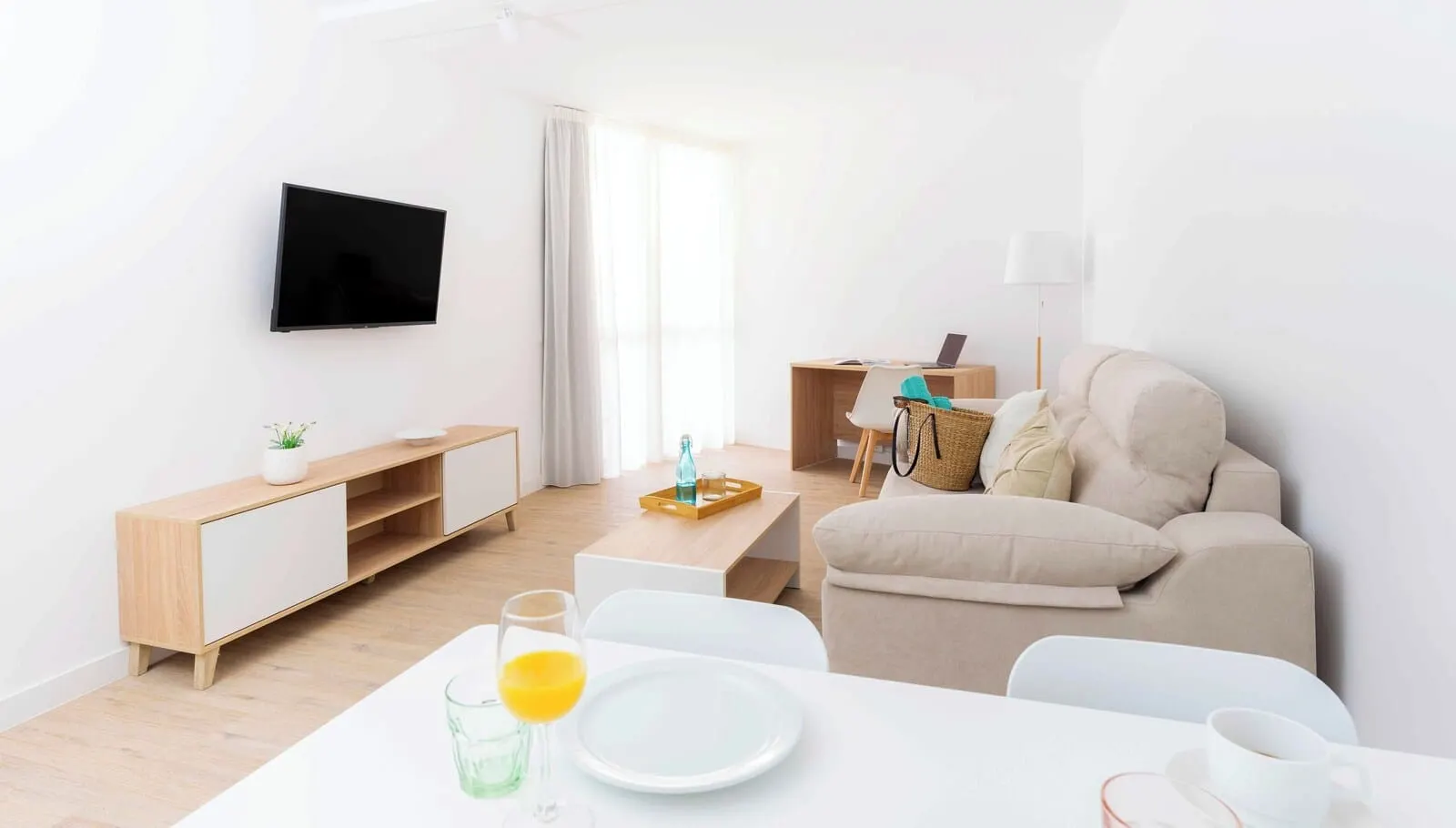 Ona Alborada: A modern living room with a sofa, a TV mounted on the wall, a wooden sideboard
