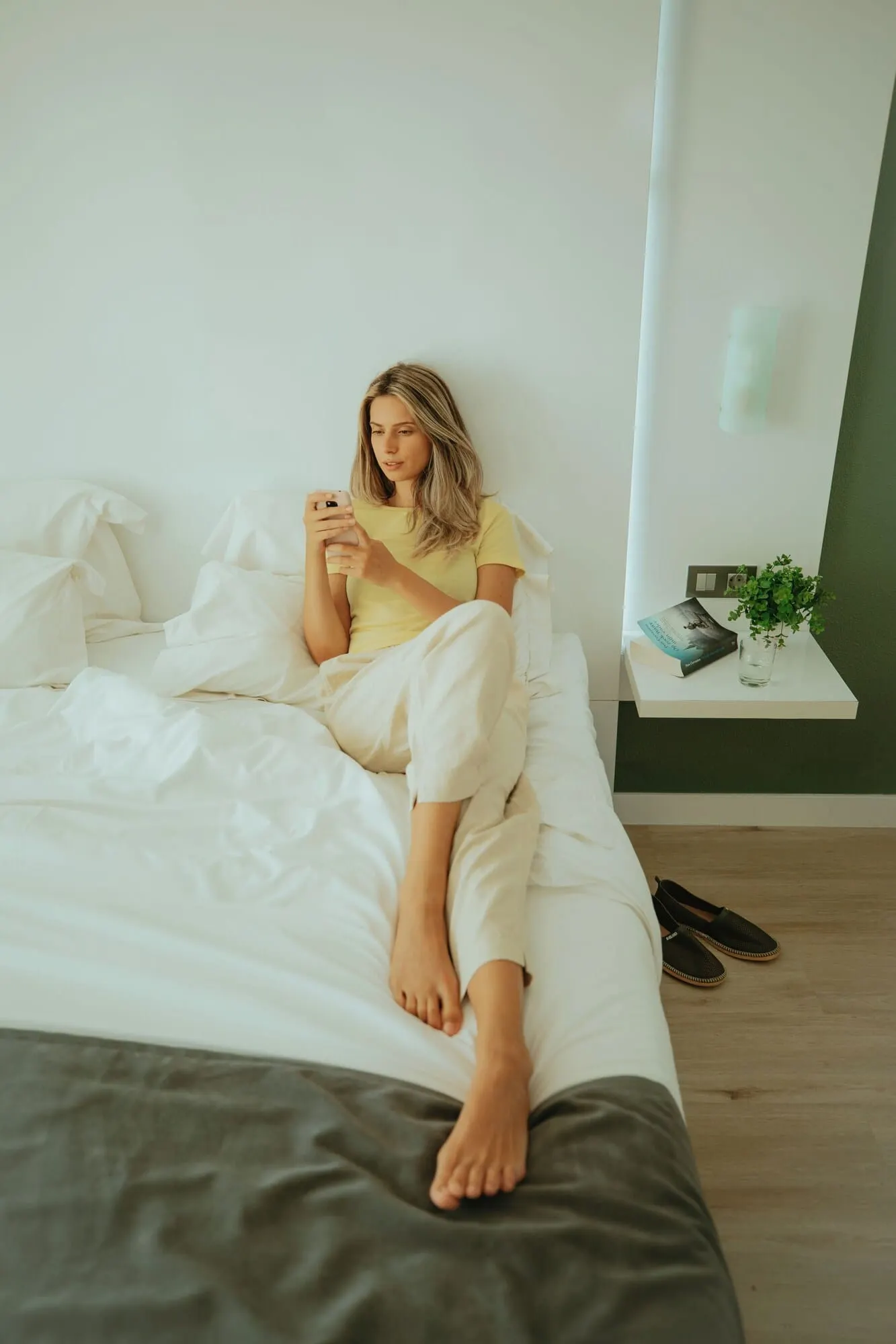 Olé Tropical Tenerife: A person sitting on a bed in a room with a white wall