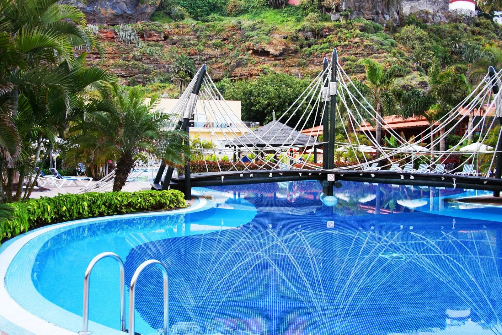Bahia Principe Explore San Felipe: A swimming pool with a rope bridge, palm trees, and a mountainous backdrop