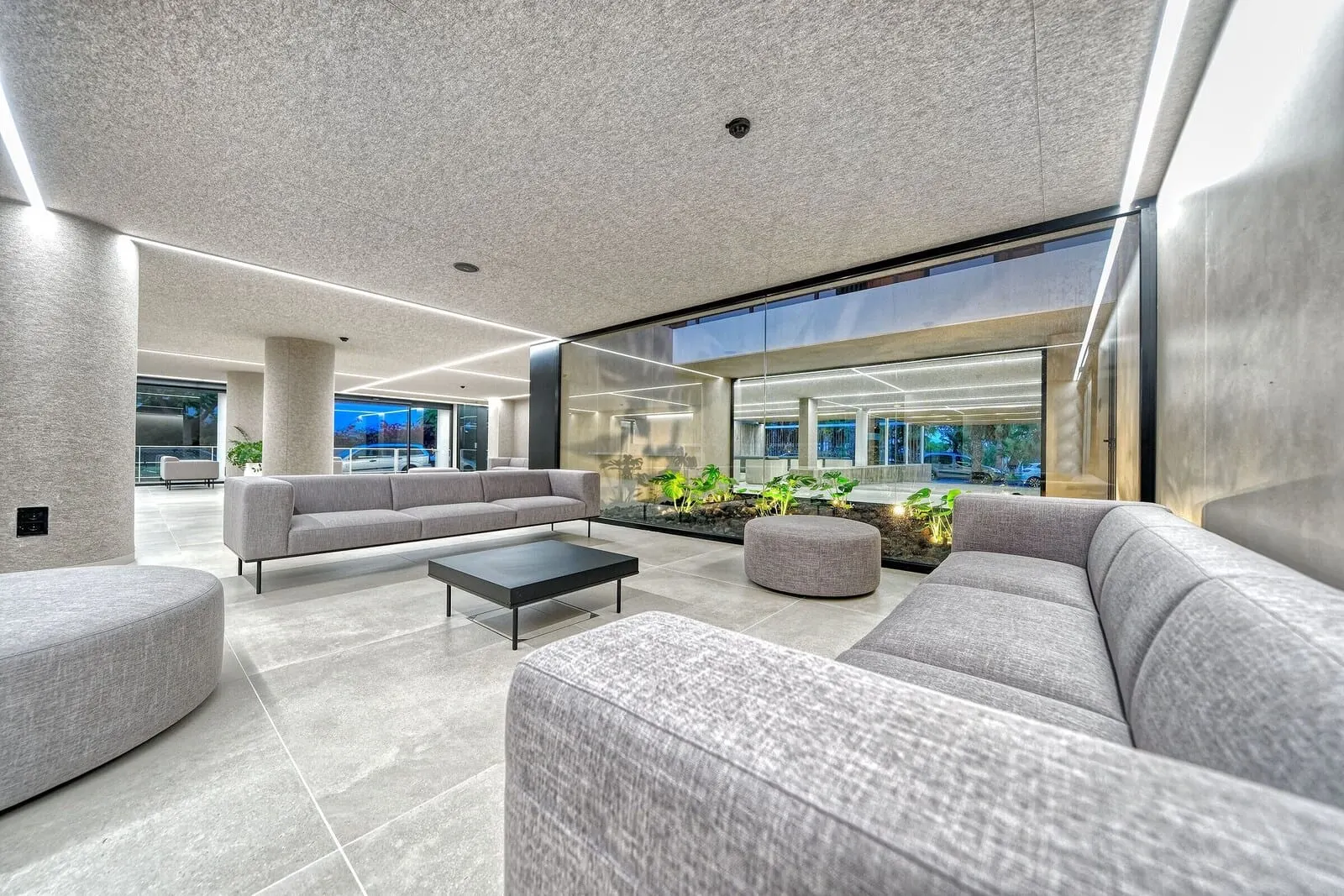 Hotel Parque La Paz: A modern interior with a grey sofa, a black coffee table, and a glass partition
