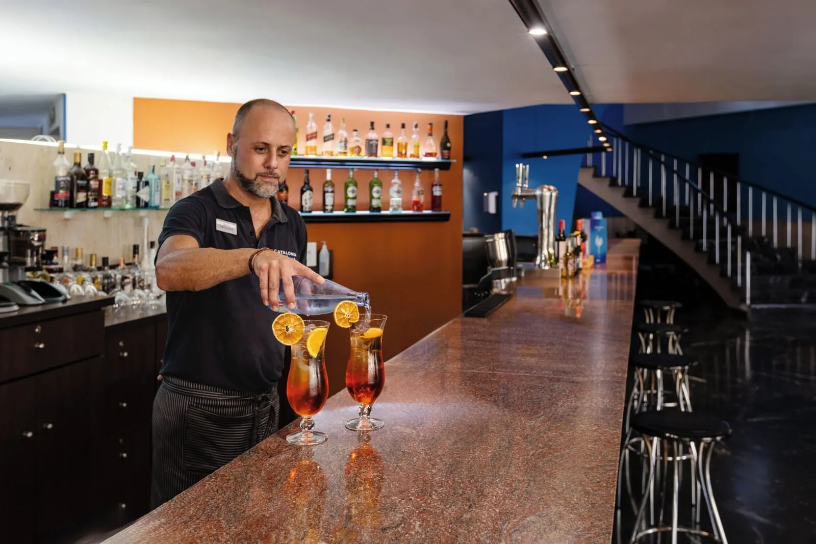 Catalonia Las Vegas: A bar area with a bartender preparing drinks. There are multiple bottles and glasses on
