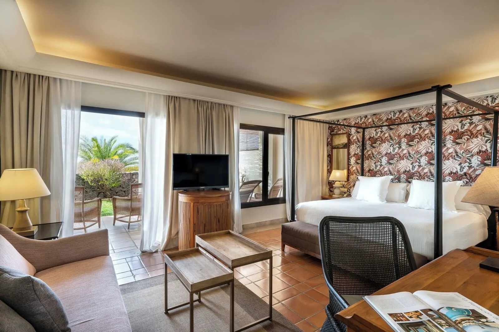 Vincci Selección La Plantación del Sur: A hotel room with a bed, a TV, a dining table, a sofa