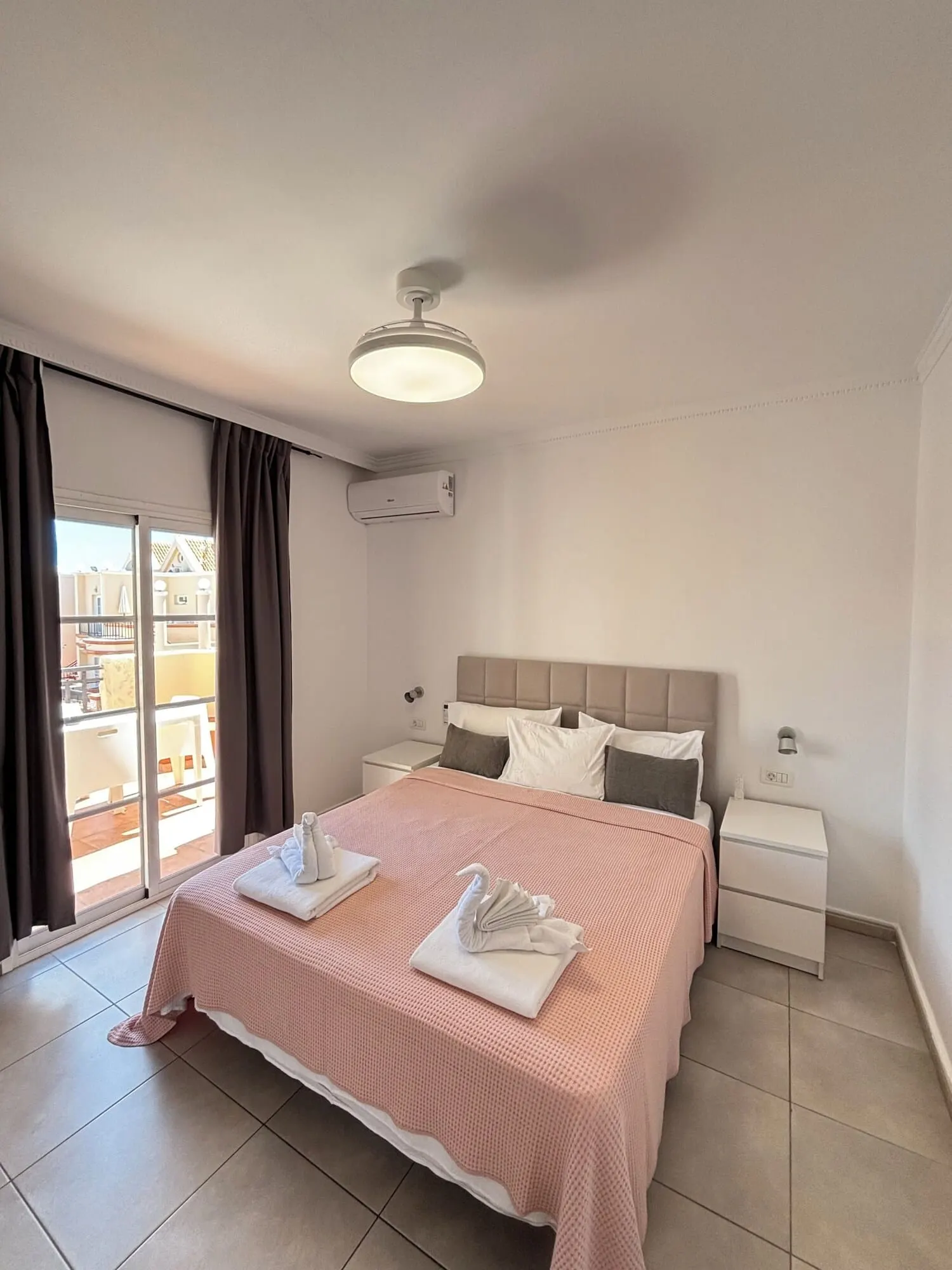 Yucca Park Aparthotel: A hotel room with a bed, a nightstand, an air conditioning unit, a ceiling light