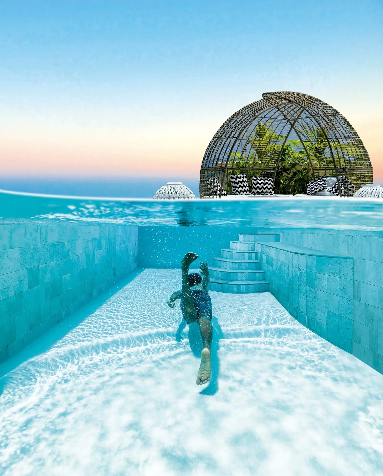 Royal River: A person swimming in a clear blue pool with a dome-shaped structure in the background