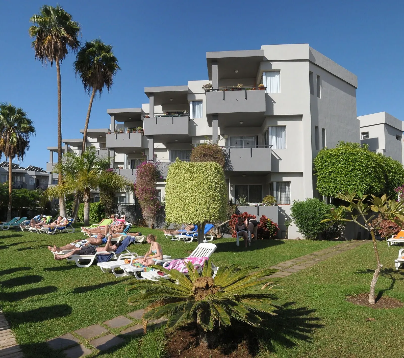 HG Tenerife Sur: A modern apartment building with multiple balconies, a well-maintained lawn