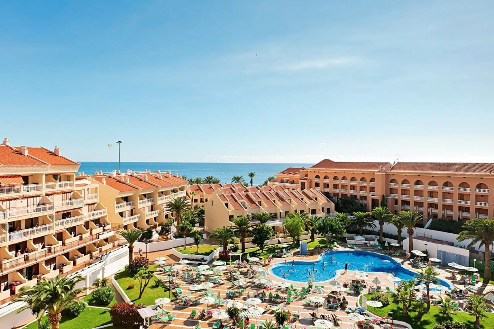 Coral Compostela Beach: A resort with multiple hotel buildings, a central swimming pool, and a view of the sea