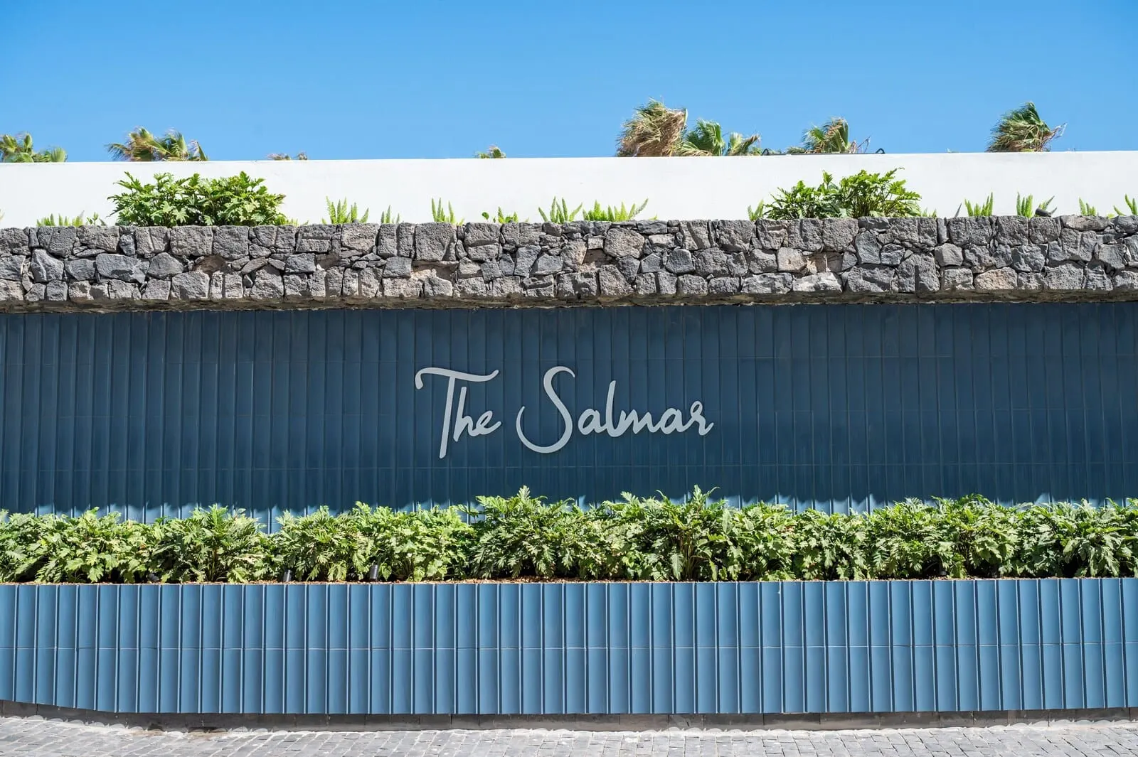 The Salmar: A building facade with a stone wall and a blue wall with 'The Salmar' written on it