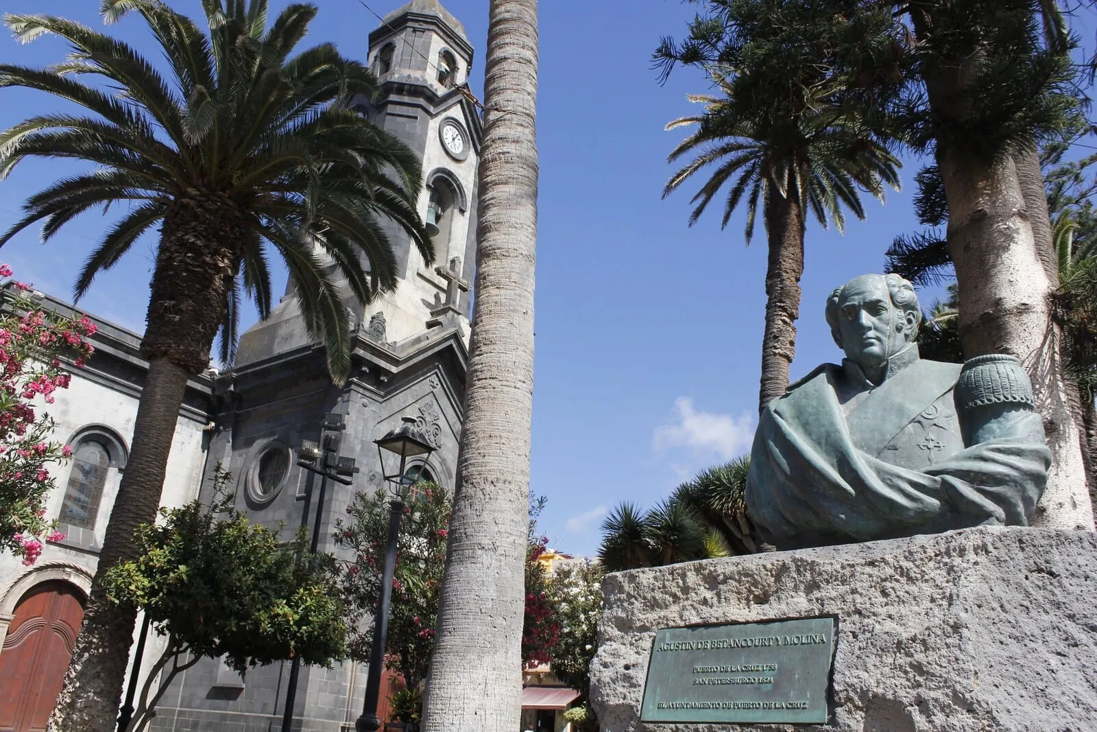 4Dreams Hotel: A statue of a historical figure, a church with a clock tower, and palm trees