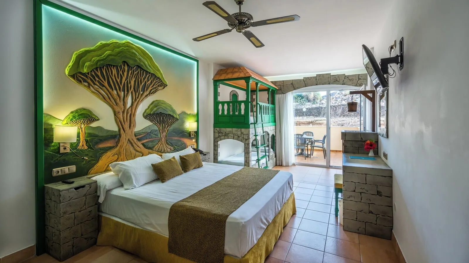 BLUESEA Costa Jardín & Spa: A bedroom with a large bed, a green tree mural, a stone fireplace