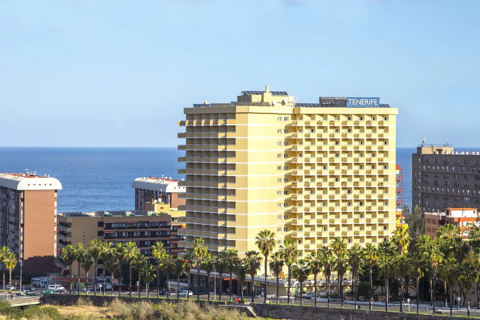 Be Live Adults Only Tenerife: A multi-story hotel with balconies, located near a beach with palm trees