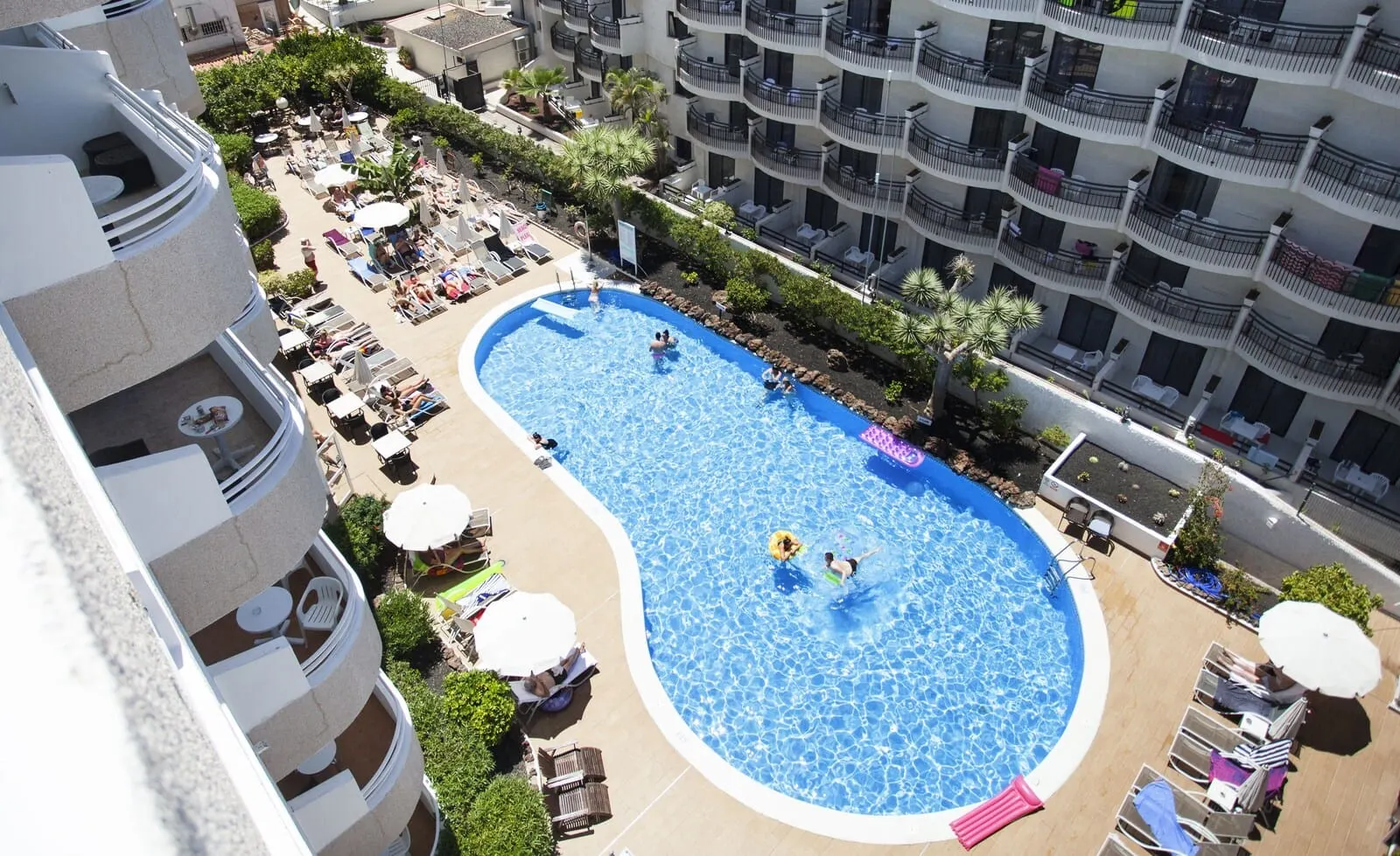 Coral California: A rooftop swimming pool surrounded by lounge chairs and umbrellas