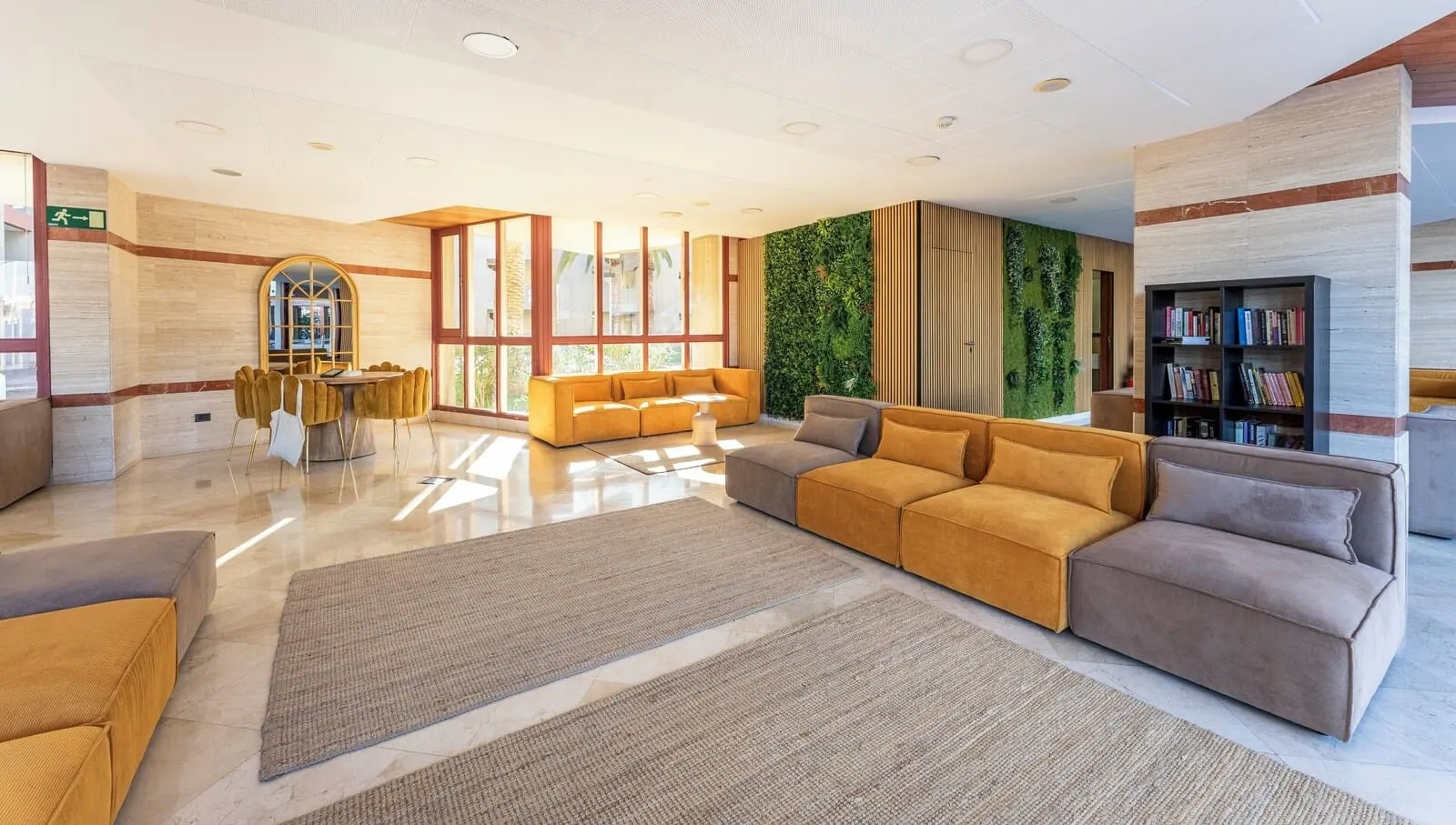 Ona Alborada: A spacious lobby with a large sofa, a coffee table, and a bookshelf