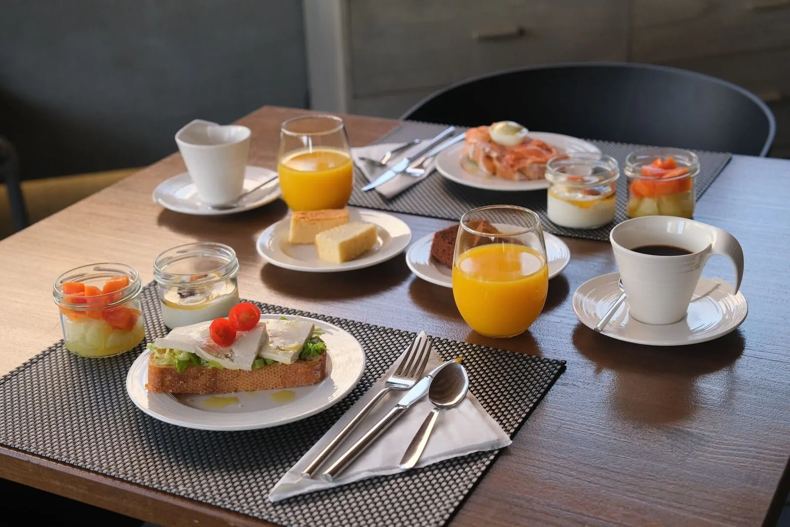 Hotel Adonis Capital: A breakfast table with various food items, including toast, fruit, and a cup of coffee