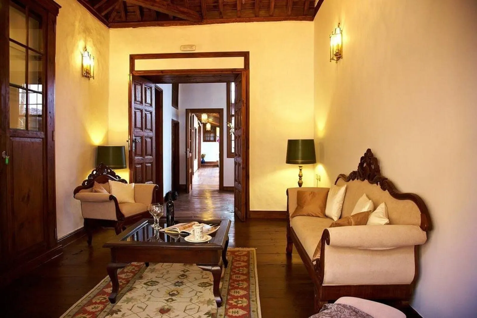 Hotel Emblemático San Agustín: A traditional hotel lobby with wooden furniture, a coffee table, and two lamps