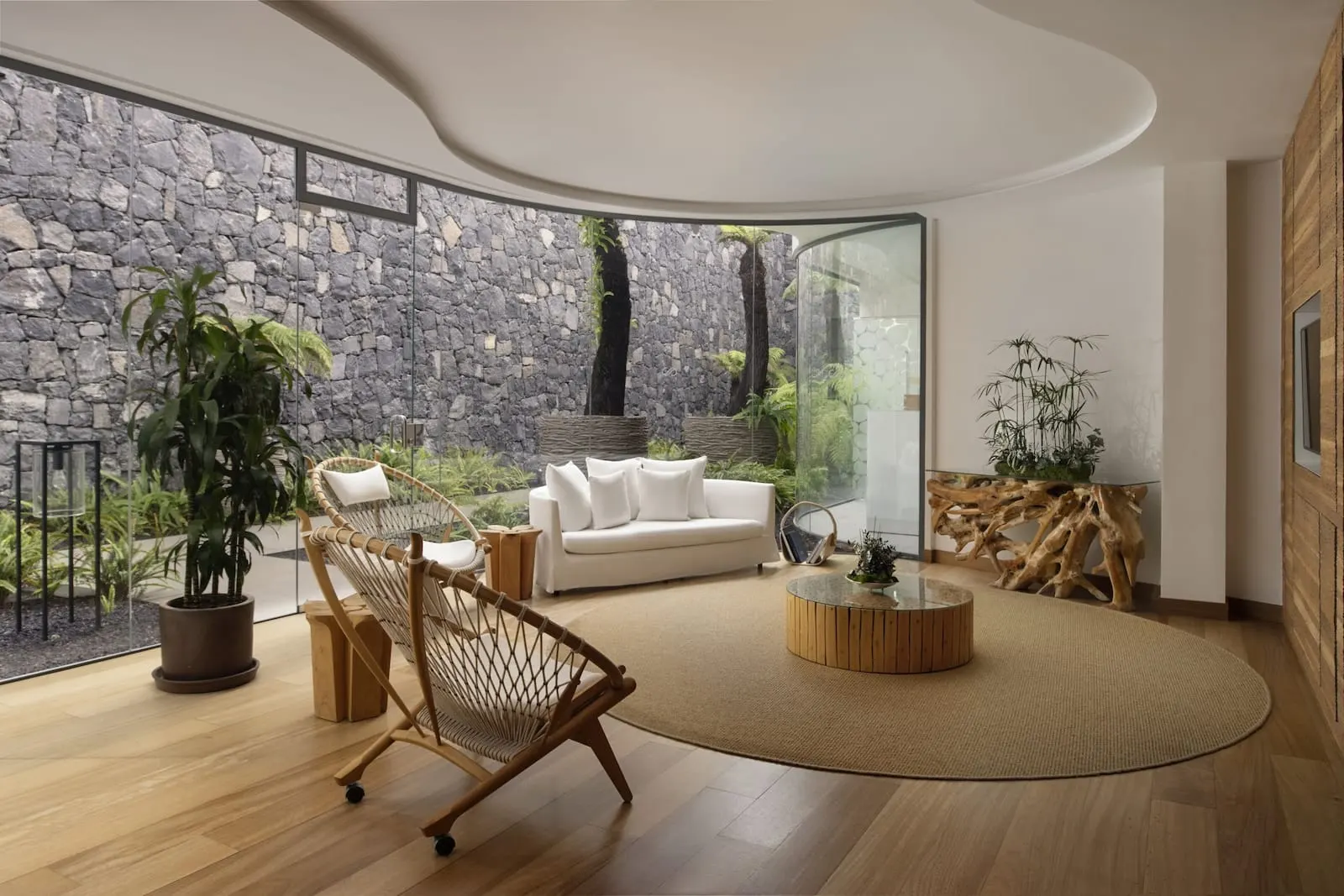 Royal Hideaway Corales Beach: A modern living room with a white sofa, a wooden chair, a round coffee table