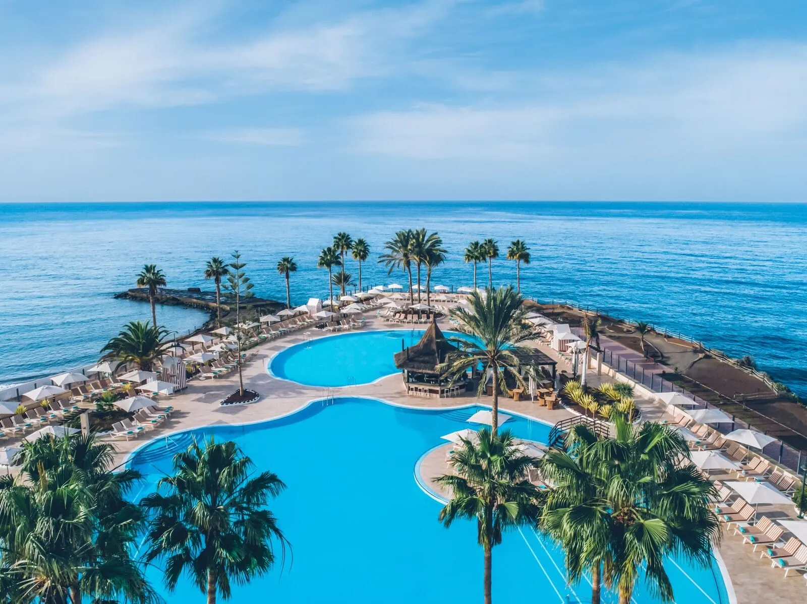 Iberostar Selection Anthelia: A resort pool area with multiple swimming pools, palm trees, and lounge chairs