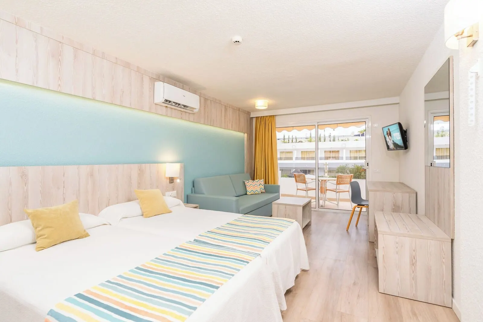 HOVIMA Panorama: A hotel room with a large bed, a sofa, a desk, and a TV
