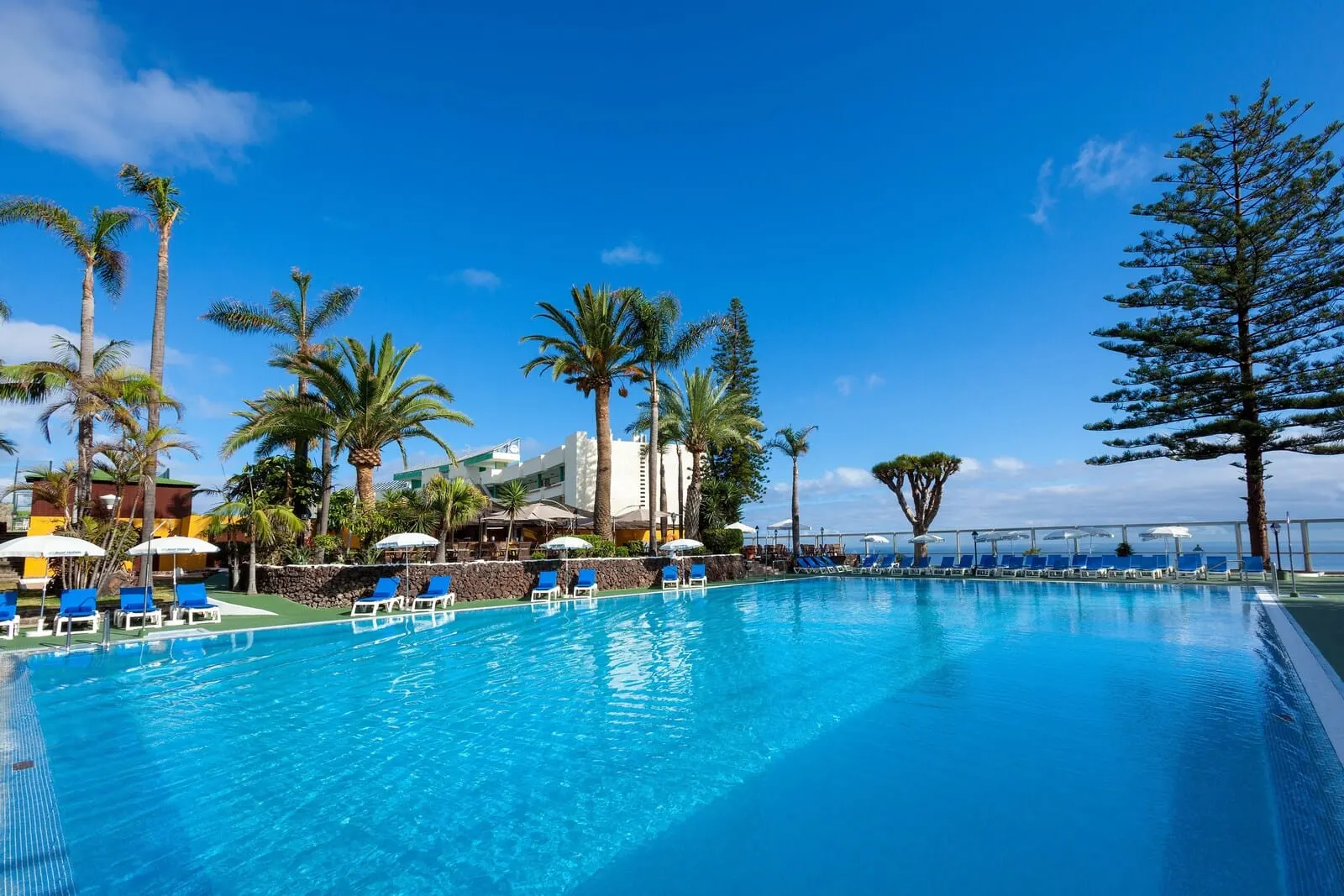 Best Semiramis: A clear blue pool with blue lounge chairs and umbrellas