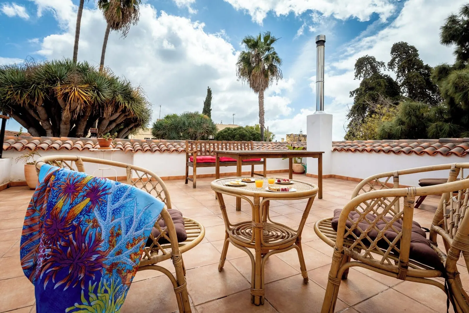 Hotel Duque de la Torre: An outdoor patio with wicker furniture, a round table with food