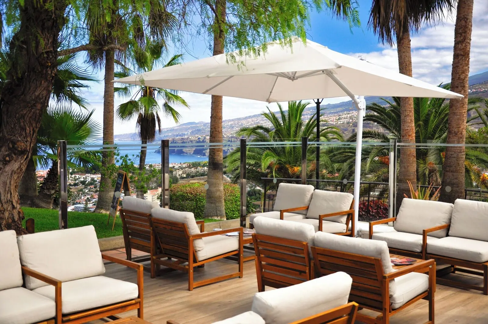 Hotel Las Águilas Tenerife, Affiliated by Meliá: A terrace with wooden furniture and a white umbrella