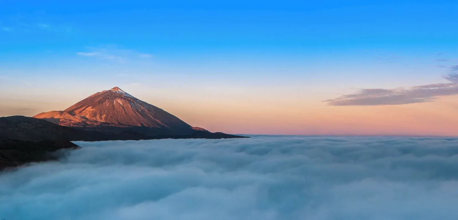 Hotel Adonis Capital: A mountain peak with a clear sky above and clouds below
