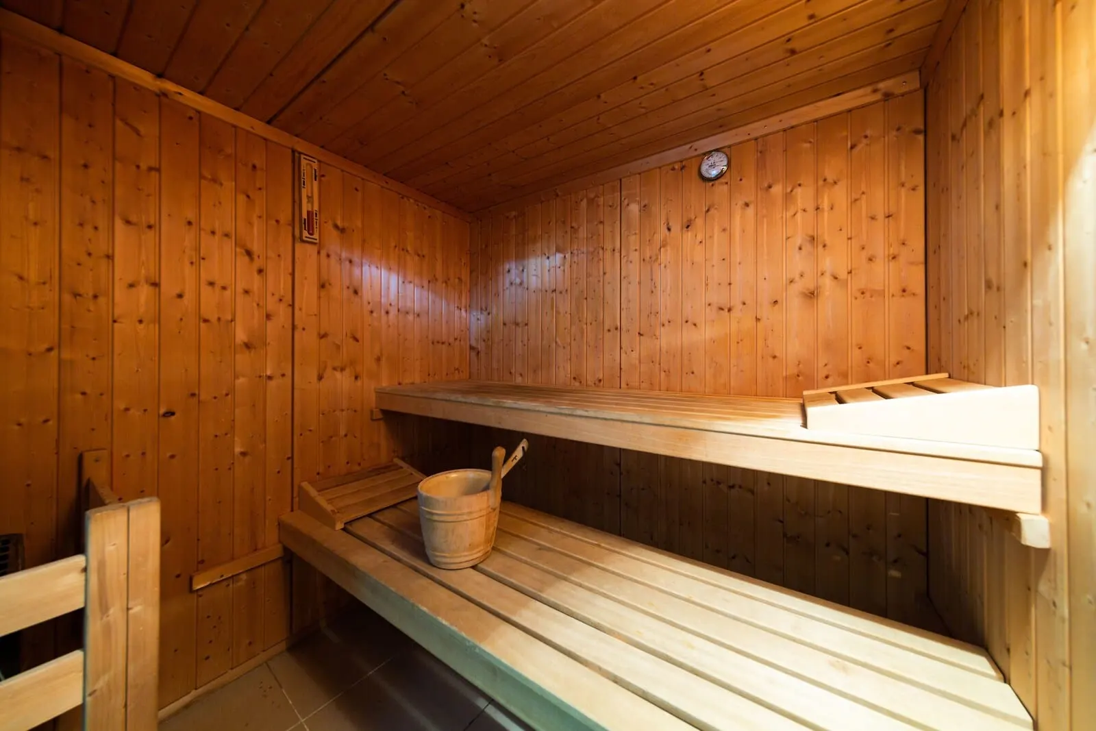 Hotel Marte: A wooden sauna with benches and a bucket