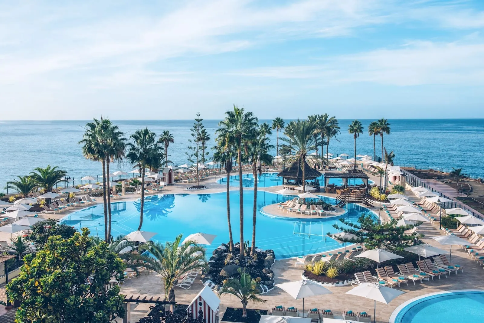 Iberostar Selection Anthelia: A resort with multiple swimming pools, palm trees, and lounge areas with umbrellas