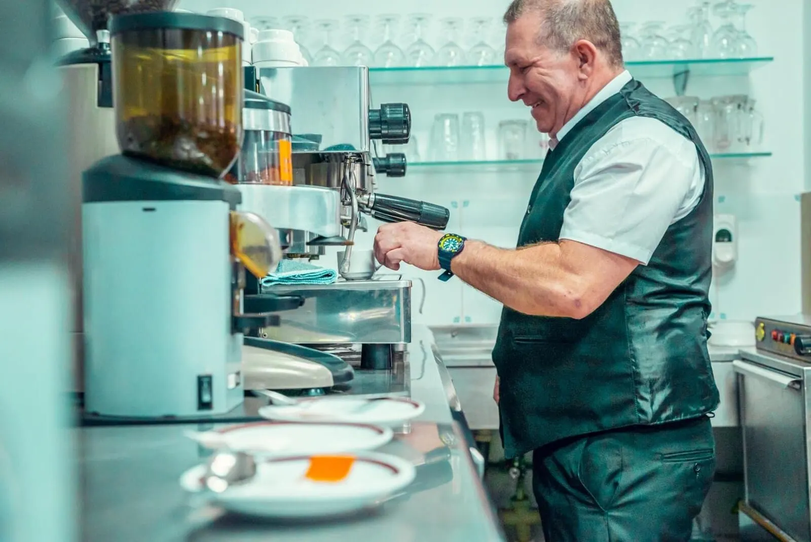 Hotel Tropical: A person operating a coffee machine in a kitchen setting