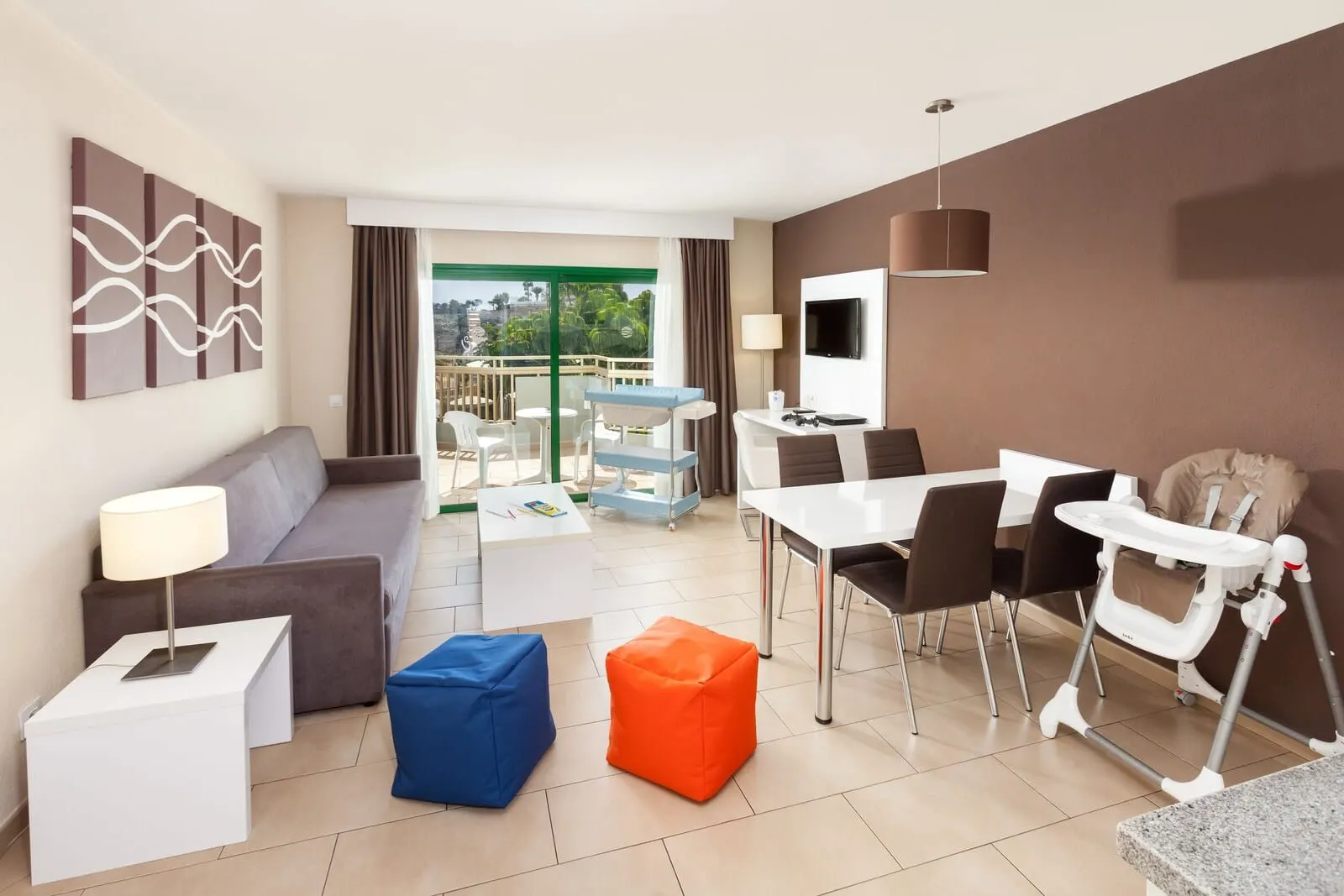 Playaolid Suites & Apartments: A modern hotel room with a balcony, a dining area, a sofa, a TV