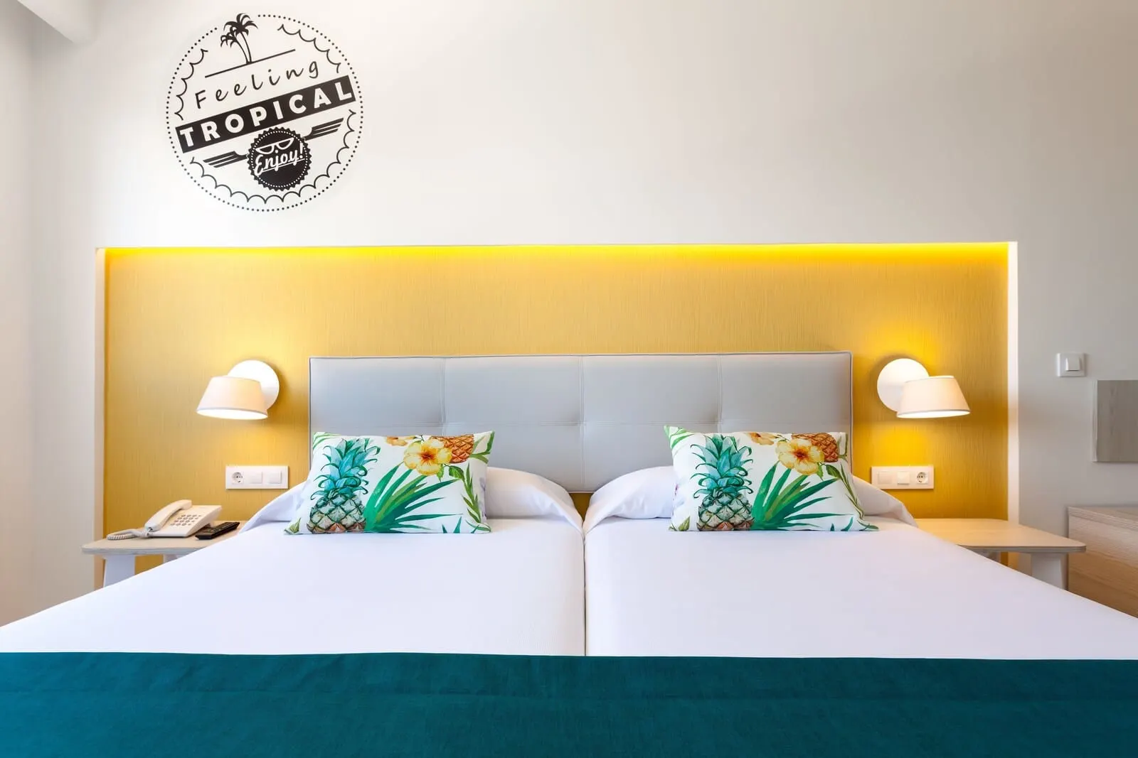 Hotel Tropical Park: A hotel room with a bed, two nightstands, a phone, and a tropical-themed wall decal