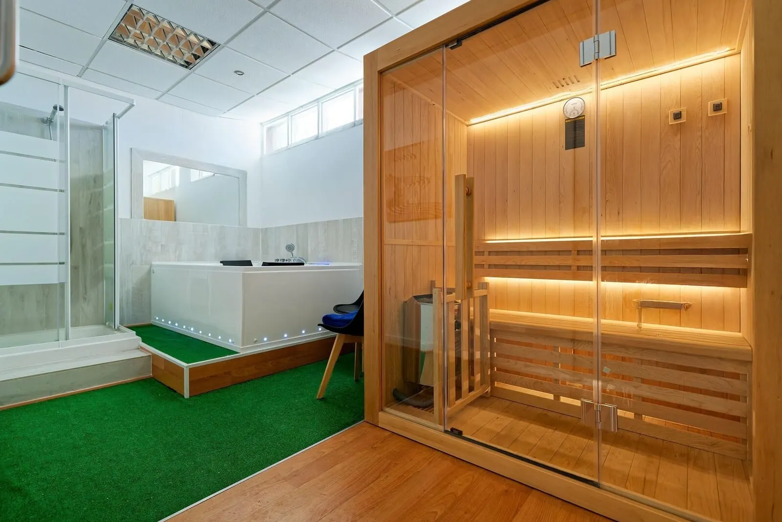 Servatur Caribe: A sauna room with a wooden bench, a glass door, and a small blue chair